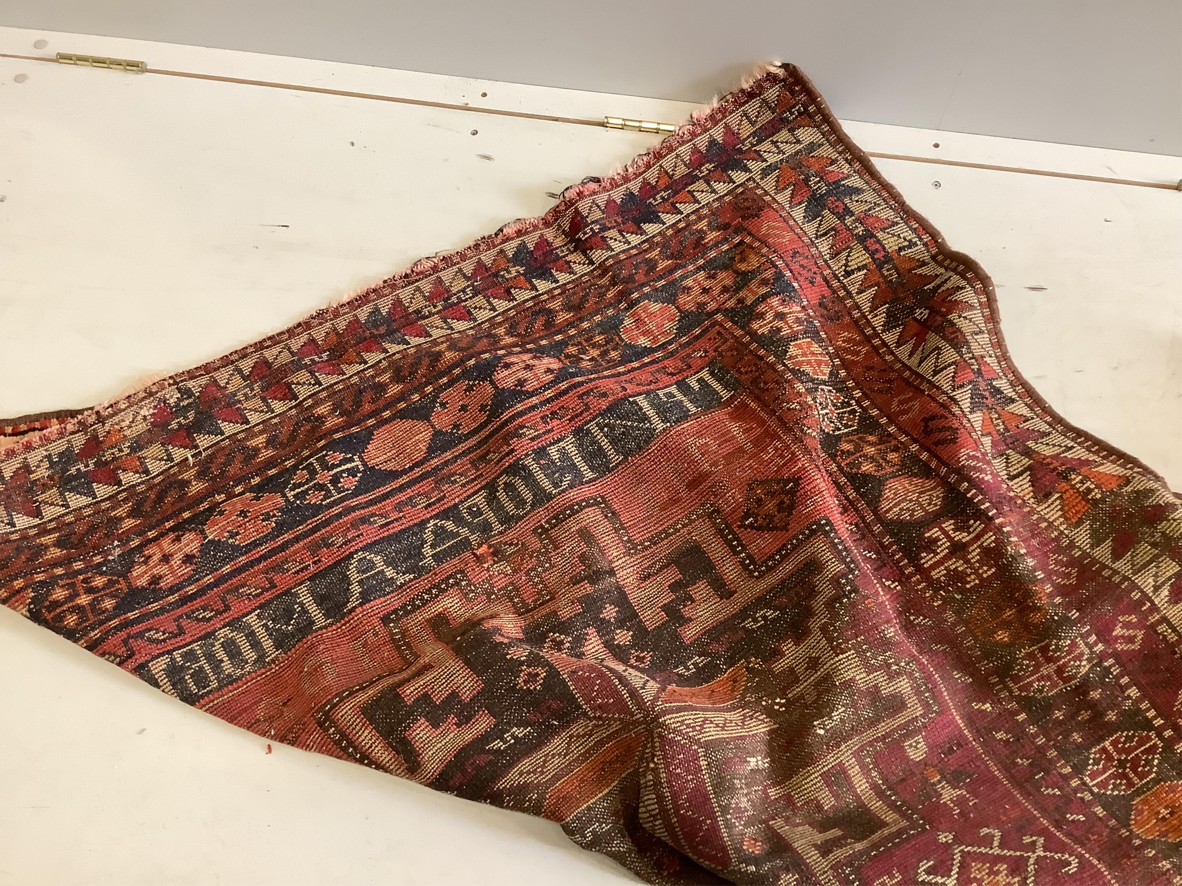 A Caucasian red ground rug, 250 x 130cm. Condition - fair